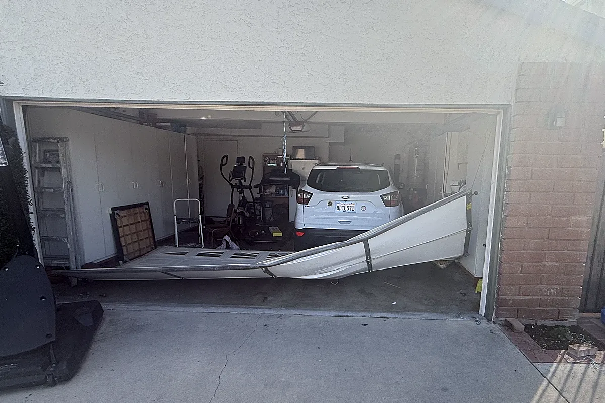 Before: dented and damaged garage door panel